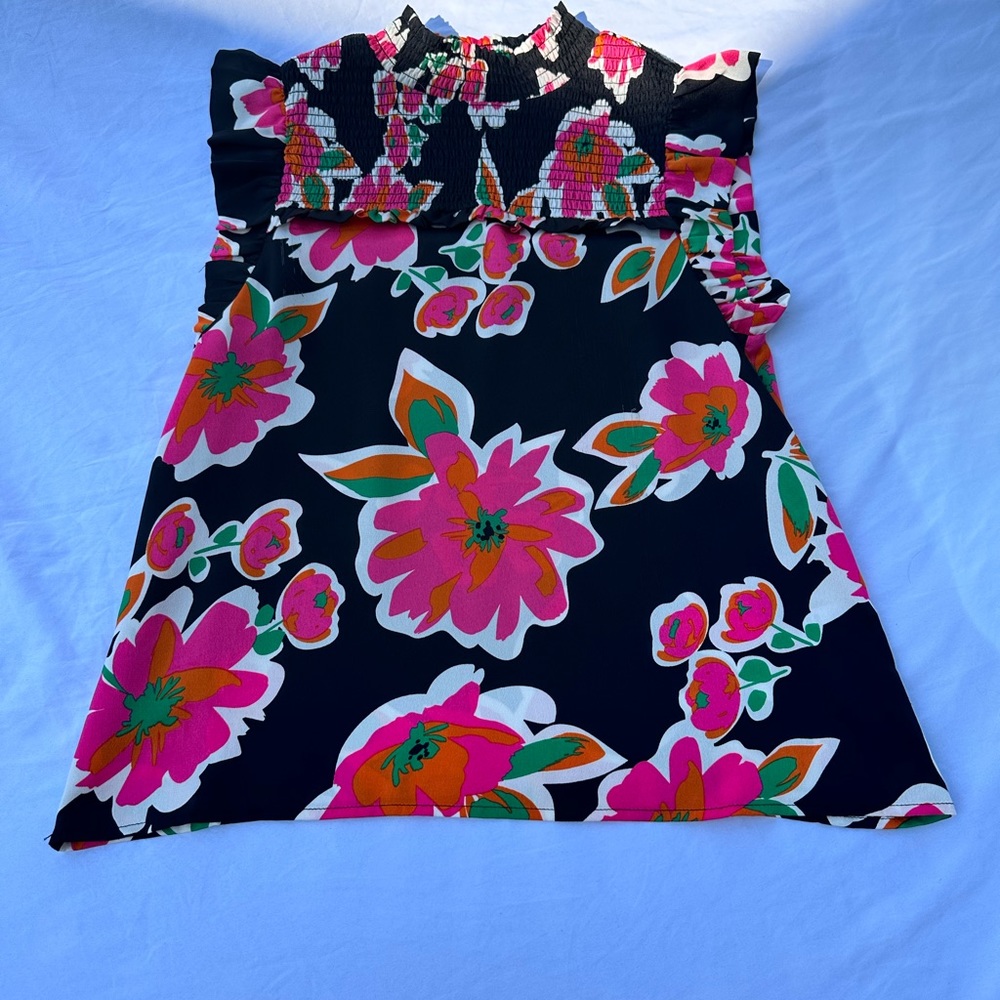 Cute floral print tank with ruffle sleeves and a mock neck!